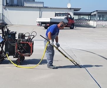 Ein Mitarbeiter bearbeitet Fugen mit einer Maschine
