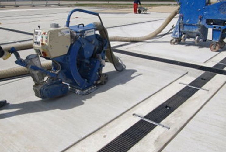 Images of the shot peening process on asphalt with blue machines